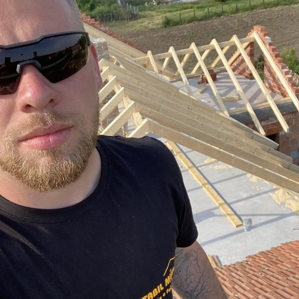 Tóth Csaba egy készülő tetőszerkezet mellett